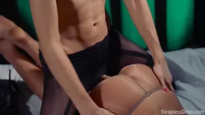 Lesbians using a strapless dildo in acrobatic sex positions