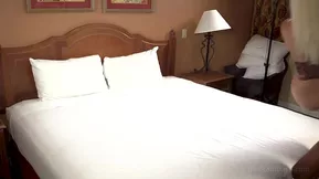 A young woman gives a black man oral sex in her kitchen.