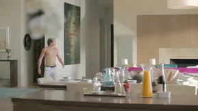 A beautiful young couple enjoys a passionate experience in the kitchen during breakfast